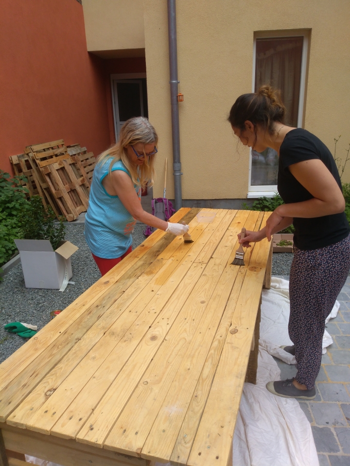 Twee vrouwen knappen een tuintafel op - © Straatverplegers