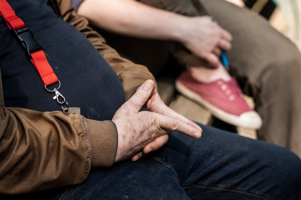 Image rapprochée de mains posées sur les jambes en mode réflexion